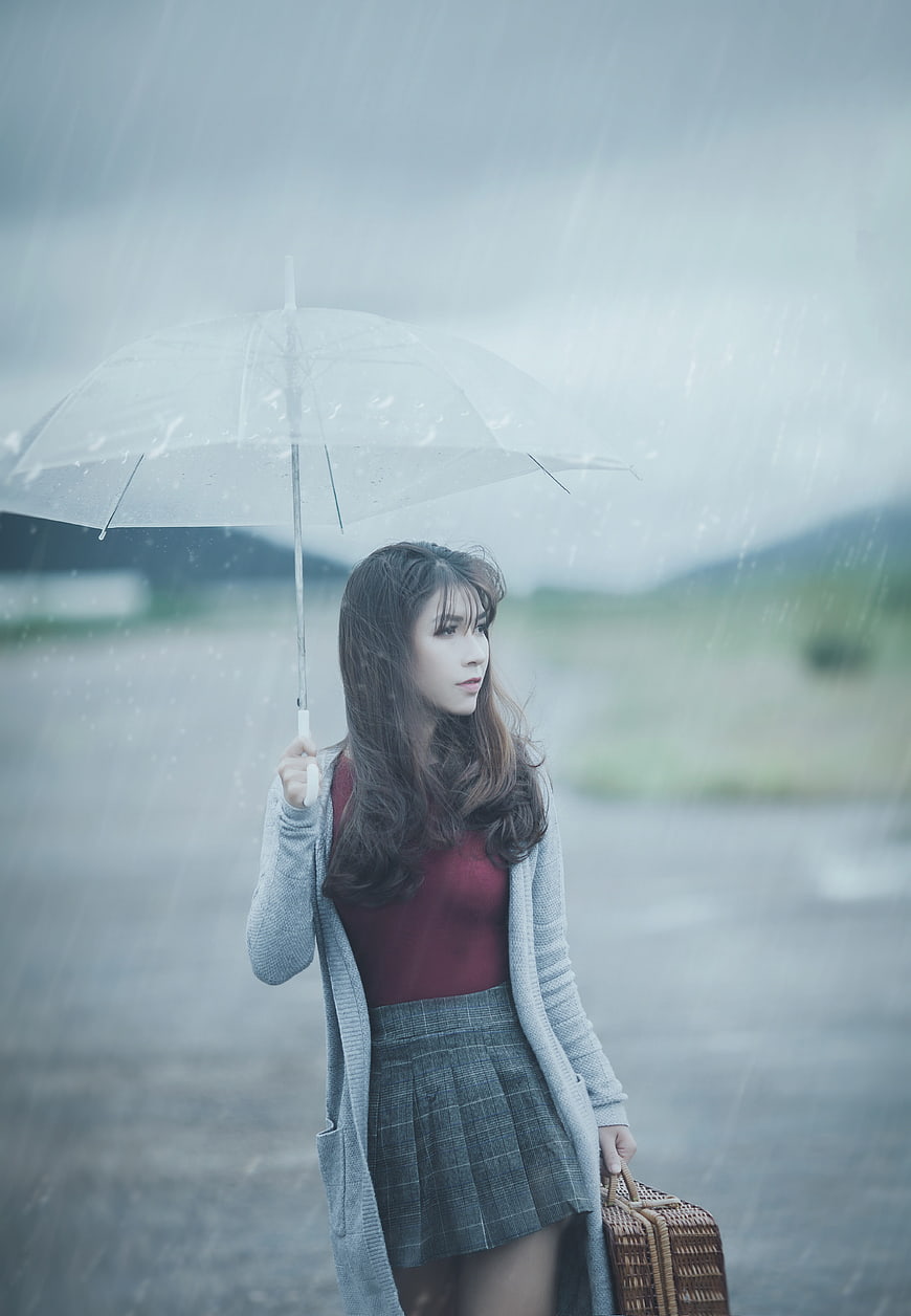 Woman with Umbrella in Rainy Landscape