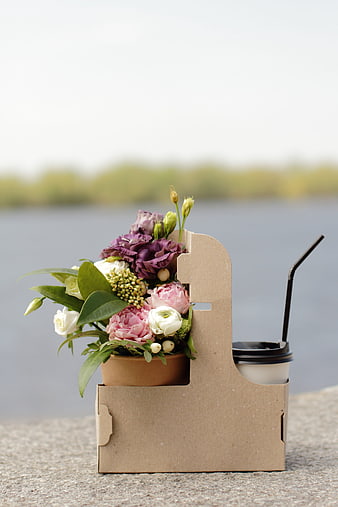 Creative cardboard carrier holding a flower bouquet and coffee cup