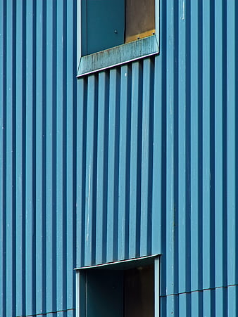 Blue corrugated metal wall with industrial windows