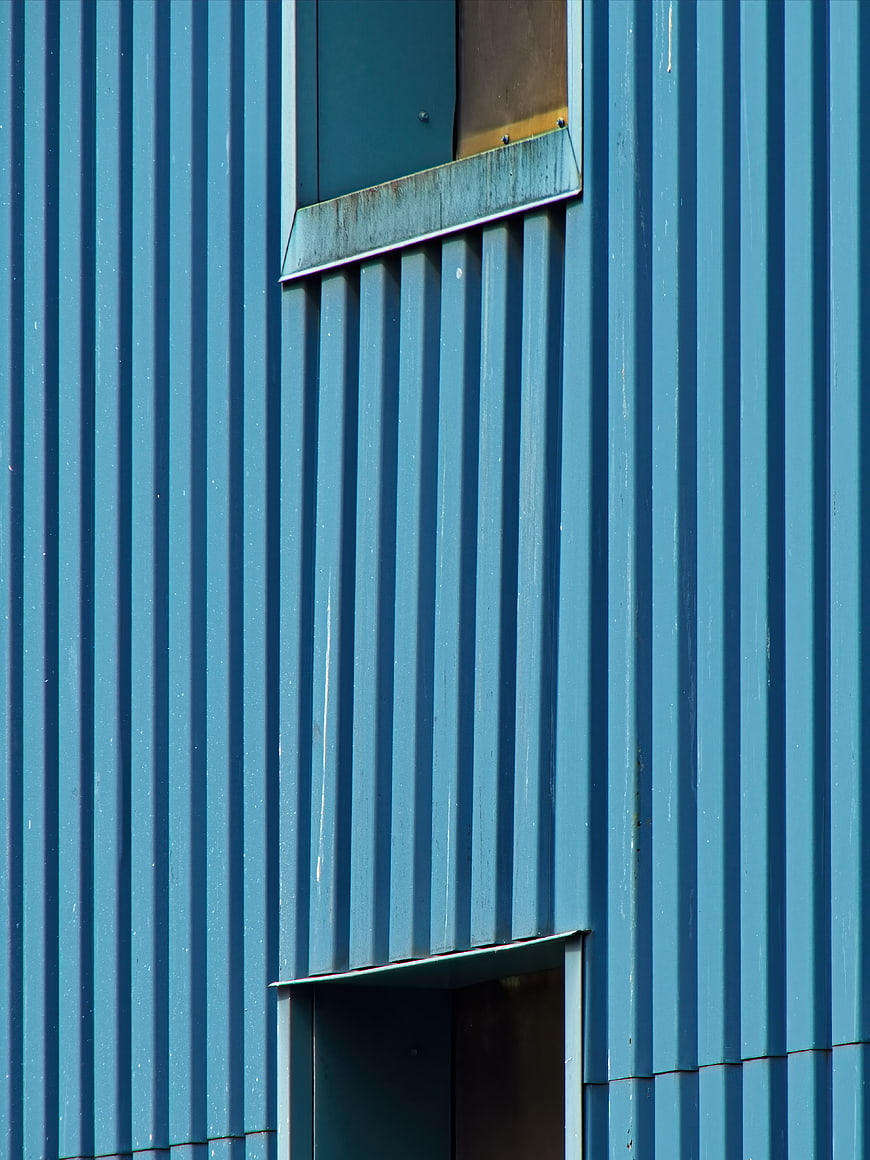 Blue corrugated metal wall with industrial windows