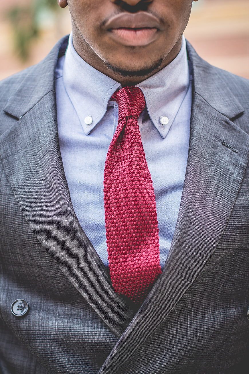 Close-up of man in grey suit with red knitted tie