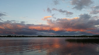 Serene Lake Sunset Landscape With Dramatic Clouds And Water Reflections