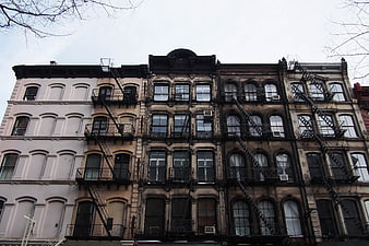 Row of historic brownstone buildings with fire escapes