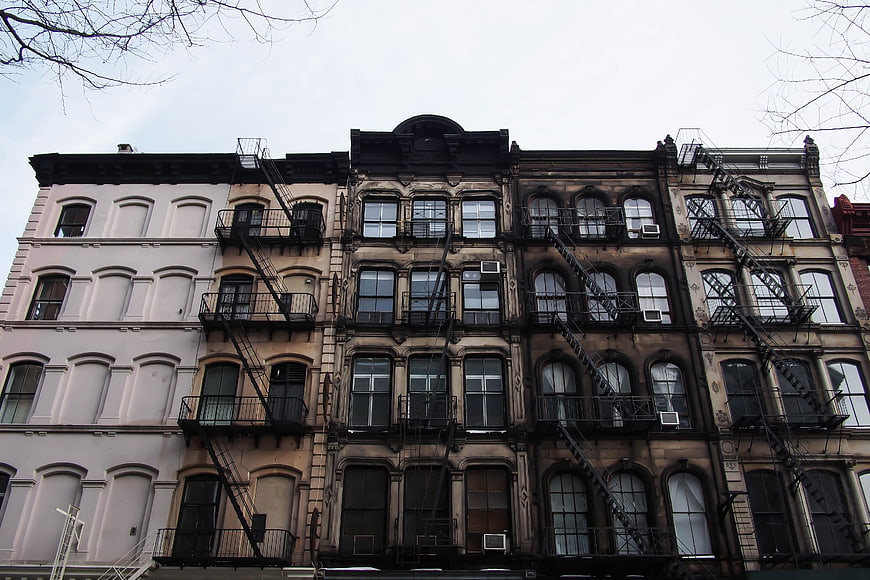 Row of historic brownstone buildings with fire escapes