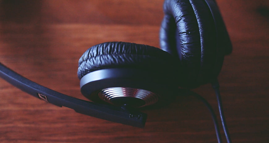 Close-up of black headphones on wooden table