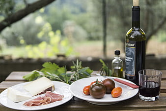 Outdoor Picnic Spread With Wine, Cheese, and Tomatoes