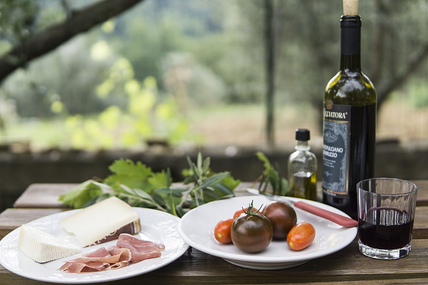 Outdoor Picnic Spread With Wine, Cheese, and Tomatoes