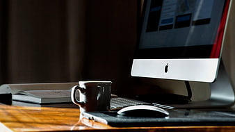 Modern Workspace with iMac, Coffee Cup, and Notebook