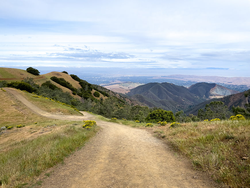 Dirt Trail Winding Through Golden Hills with Distant Valley View