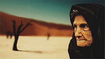 Portrait of elderly Bedouin woman in desert landscape