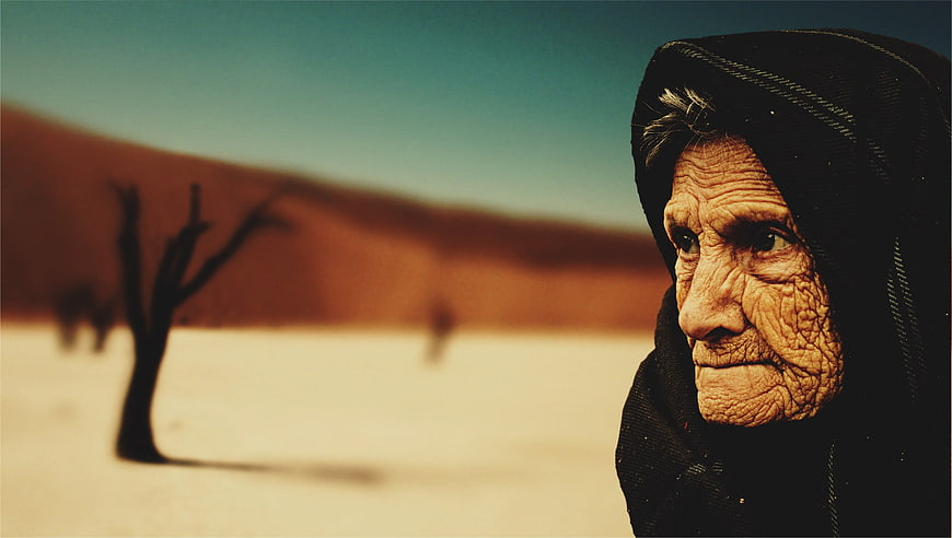 Portrait of elderly Bedouin woman in desert landscape
