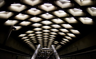 Abstract geometric ceiling pattern with lights and metal railing