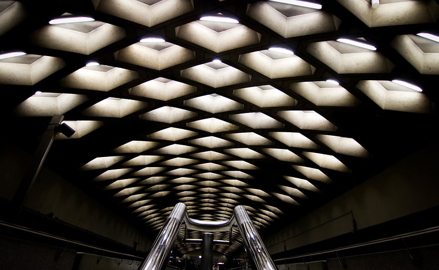Abstract geometric ceiling pattern with lights and metal railing