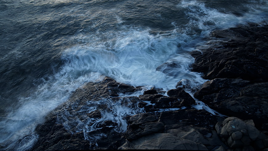 Crashing Ocean Waves on Dark Rocky Coastline