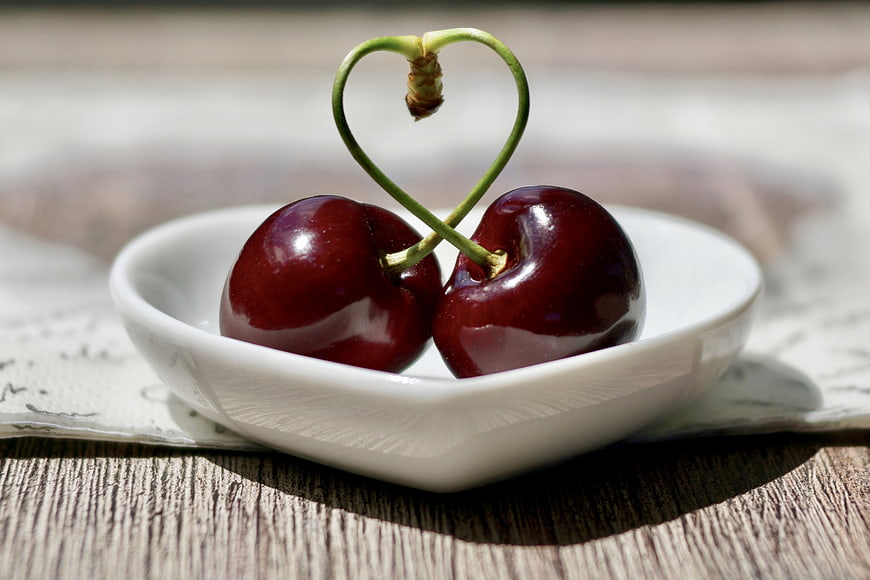 Two Cherries with Heart-Shaped Stems in White Bowl