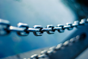 Close-up of metal chain links with blue blurred background