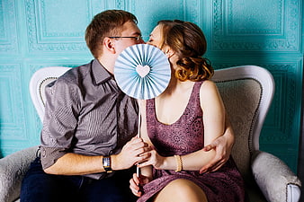Couple Holding Photo Booth Fan on Loveseat