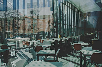 Modern restaurant interior with glass windows and city reflections