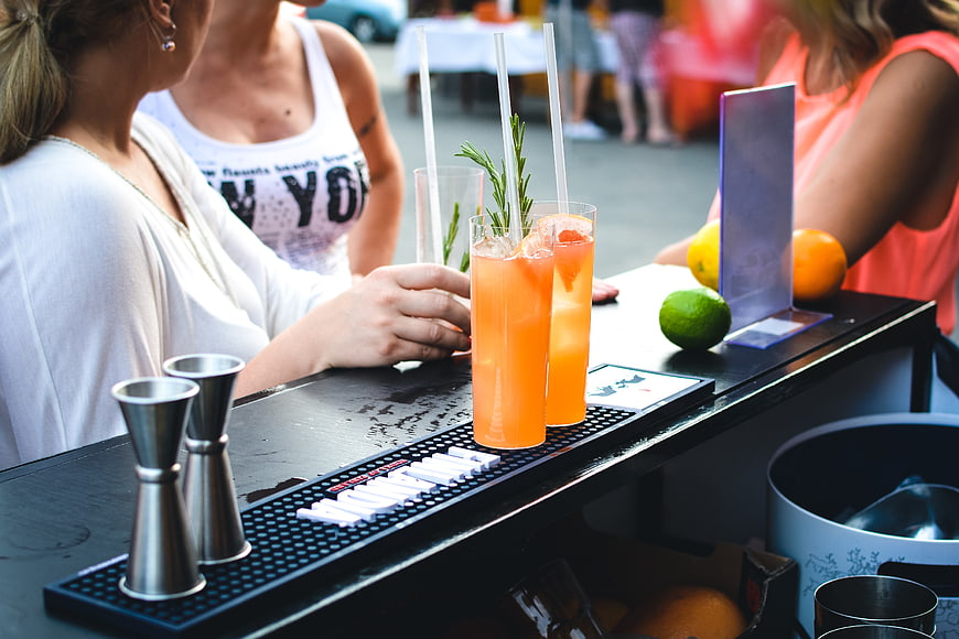 Fresh orange cocktails with rosemary garnish at outdoor bar
