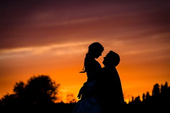 Romantic Couple Silhouette Against Vibrant Orange Sunset Sky