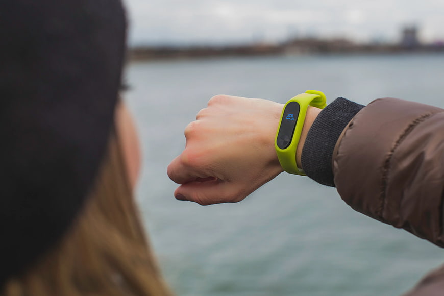 Woman Checking Green Fitness Tracker by Water