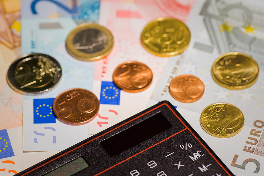 Euro coins and banknotes with calculator for finance