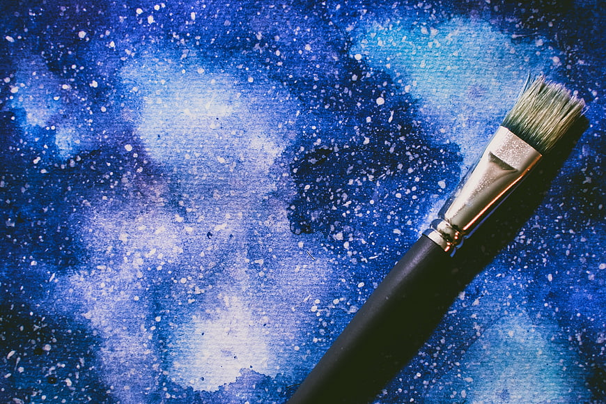 Paintbrush on Blue Galaxy Watercolor Background