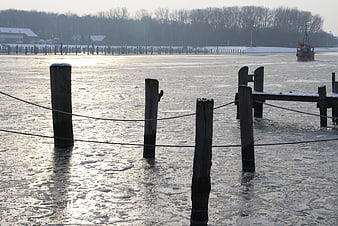 Frozen River with Wooden Pilings and Icebreaker Boat