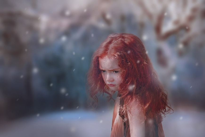Sad Redhead Girl in Snowy Winter Forest