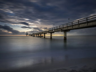 Long Exposure Concrete Pier at Sunset Over Calm Ocean