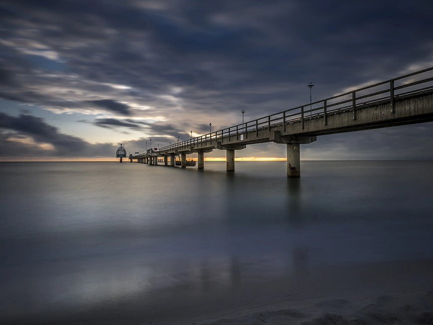 Long Exposure Concrete Pier at Sunset Over Calm Ocean