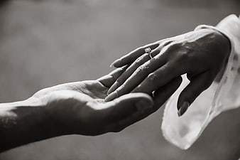 Black and white close-up of hands with engagement ring
