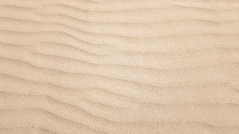 Close-up texture of rippled beige sand dunes