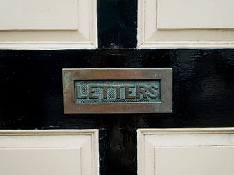 Vintage brass letters mail slot on black and white door