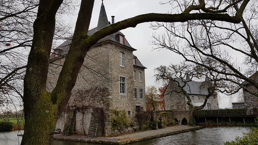 Historic stone castle with moat and bare trees in autumn