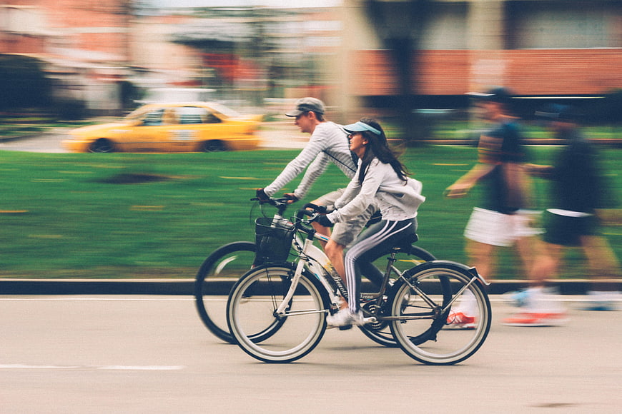 Couple Cycling Together in City Park with Motion Blur