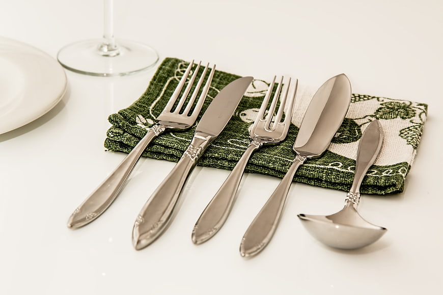 Elegant Silver Cutlery Set On Green Napkin