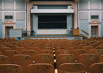 Empty Lecture Hall With Rows Of Worn Wooden Chairs