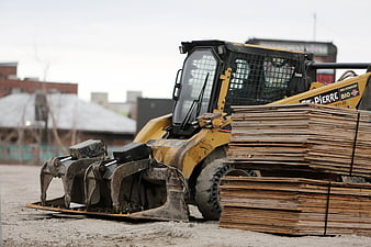 Yellow Skid Steer Loader with Forks and Wood Pallets