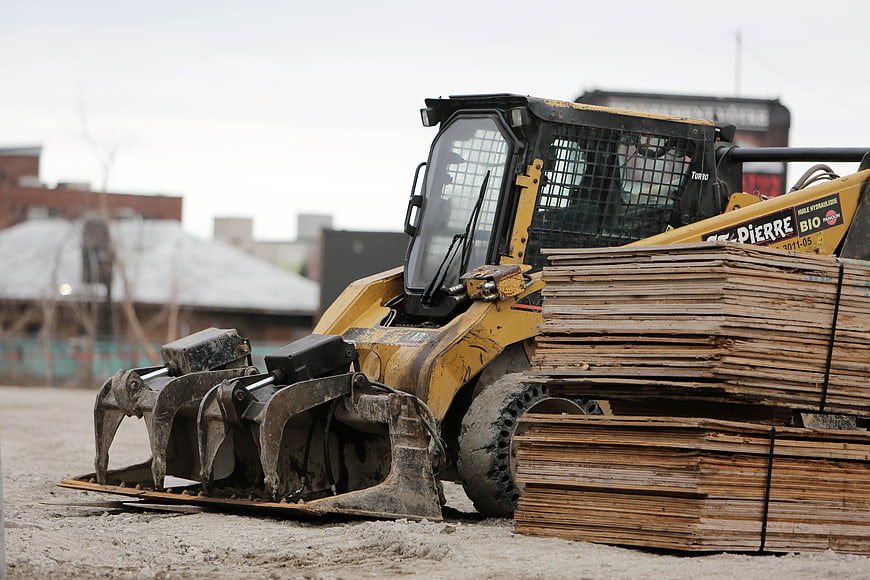 Yellow Skid Steer Loader with Forks and Wood Pallets