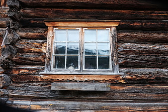 Rustic wooden window on old log cabin exterior