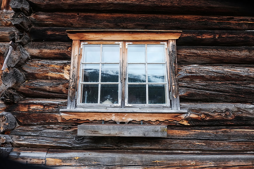 Rustic wooden window on old log cabin exterior