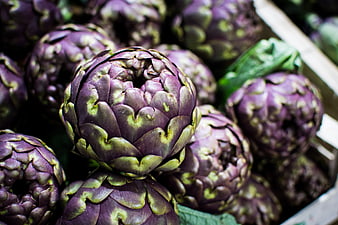 Close-up of fresh purple artichokes in a market crate