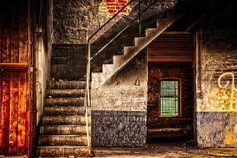 Abandoned industrial staircase with graffiti and decay