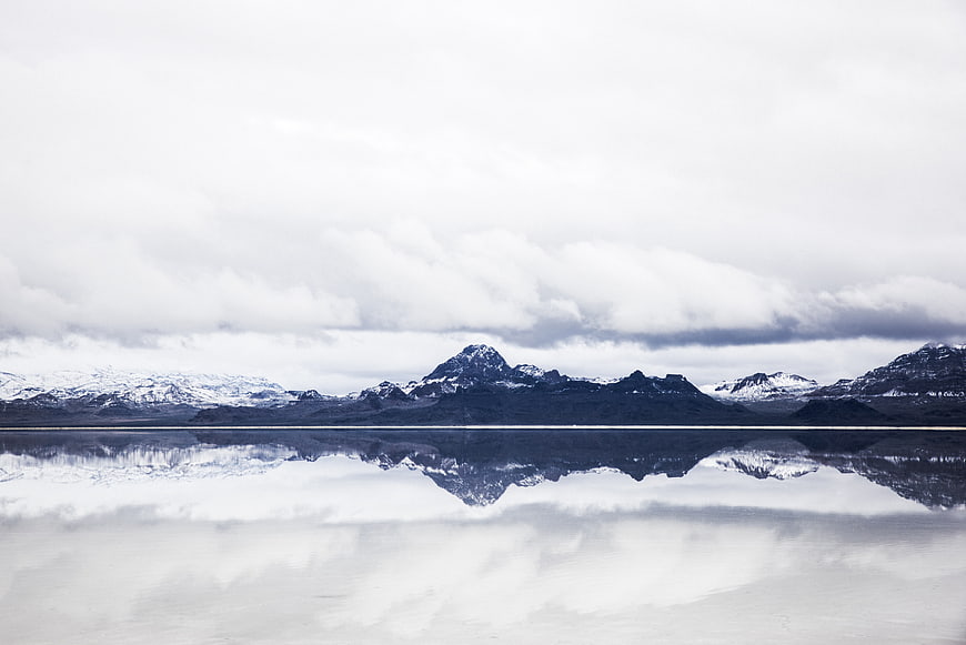 Serene Snow-Capped Mountains Reflected in Calm Water