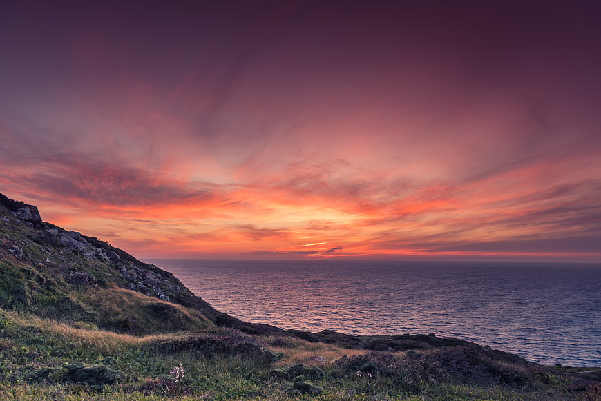 Dramatic Sunset Over Coastal Cliff and Ocean