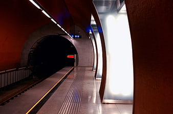 Modern subway station platform with curved illuminated walls
