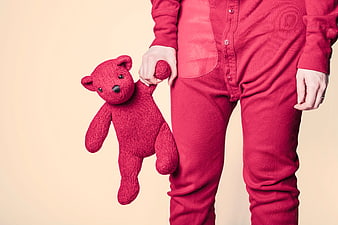 Person in Red Pajamas Holding Knitted Red Teddy Bear