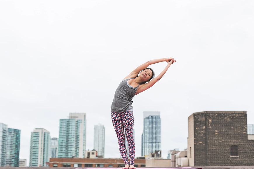Woman Stretching on Rooftop with City Skyline Background