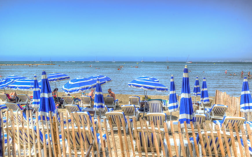 Blue and white striped umbrellas on a sunny Mediterranean beach